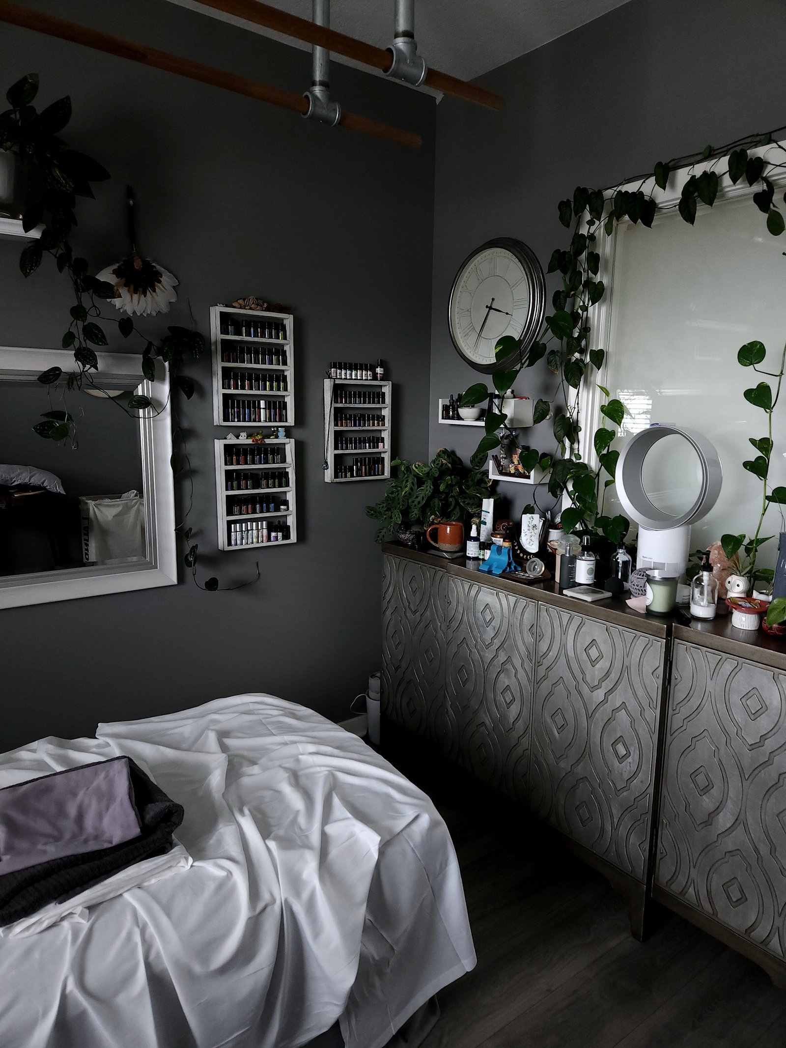 Michael's studio with oils racks, clock, and draped massage table.